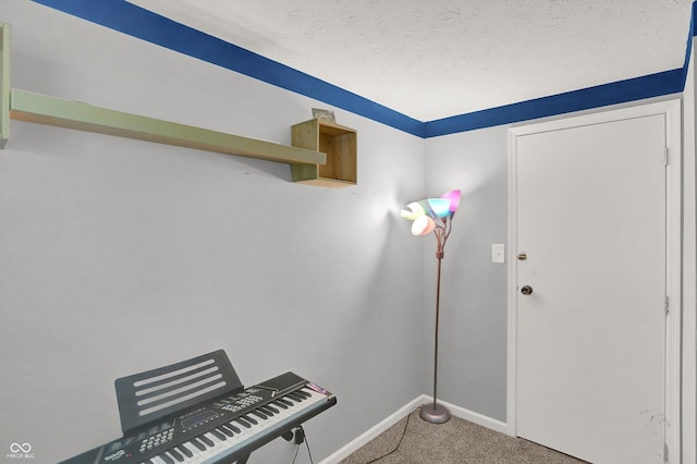 carpeted foyer entrance featuring baseboards and a textured ceiling