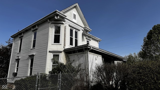 view of side of property with fence and a gate
