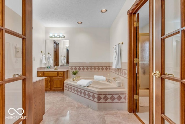7113 Lakeside Woods Dr, Indianapolis, IN 46278 - bathroom with a garden tub, tile patterned flooring, a textured ceiling, vanity, and recessed lighting