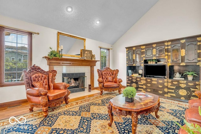 7113 Lakeside Woods Dr, Indianapolis, IN 46278 - living area with a fireplace, wood finished floors, baseboards, a textured ceiling, and high vaulted ceiling
