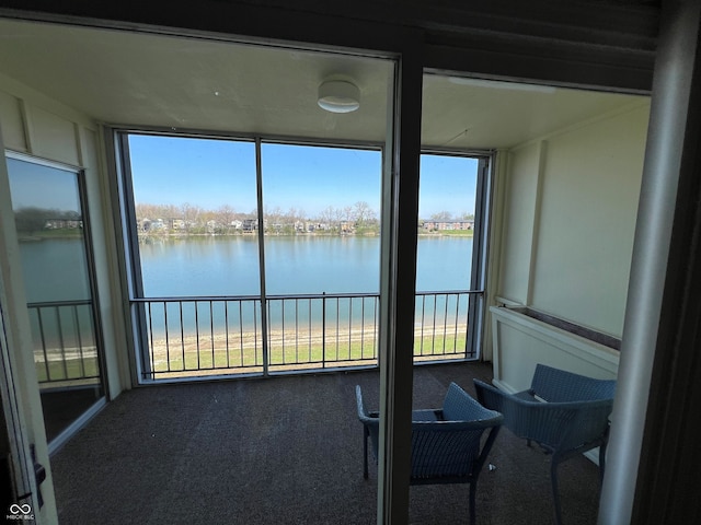 sunroom featuring a water view