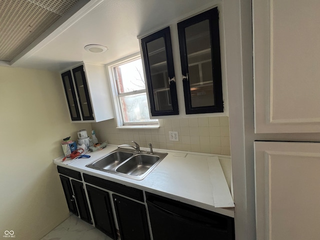 kitchen with glass insert cabinets, dark cabinets, black dishwasher, and a sink