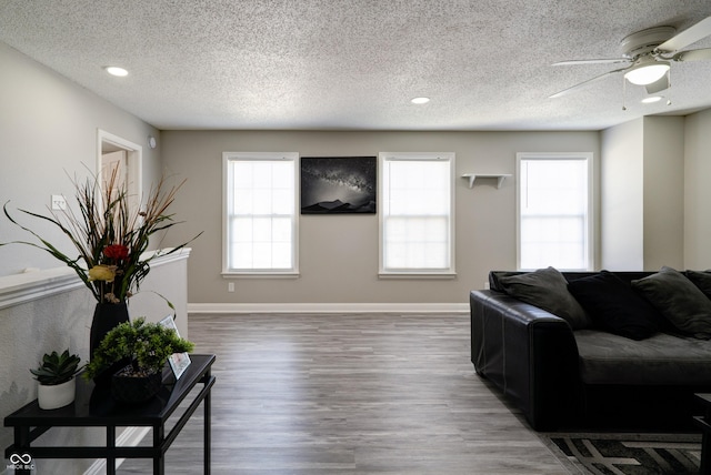10597 Cyrus Dr, Indianapolis, IN 46231 - living room with a textured ceiling, a ceiling fan, wood finished floors, baseboards, and recessed lighting