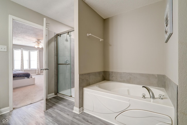 10597 Cyrus Dr, Indianapolis, IN 46231 - bathroom featuring a textured ceiling, ensuite bathroom, wood finished floors, a shower stall, and a bath