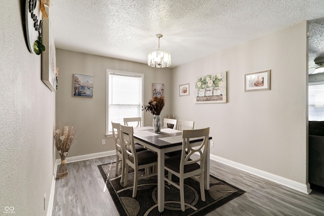 10597 Cyrus Dr, Indianapolis, IN 46231 - dining room with wood finished floors, a chandelier, baseboards, and a textured ceiling