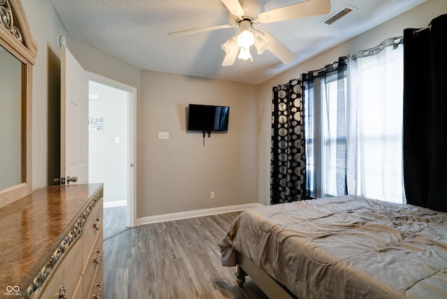 10597 Cyrus Dr, Indianapolis, IN 46231 - bedroom featuring light wood-style flooring, baseboards, a textured ceiling, and ceiling fan