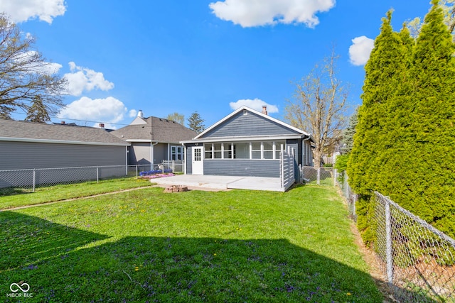 67 S 9th Ave, Beech Grove, IN 46107 - rear view of house featuring a fenced backyard, a chimney, a lawn, a sunroom, and a patio