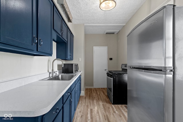 67 S 9th Ave, Beech Grove, IN 46107 - kitchen with light wood-style flooring, a sink, blue cabinetry, light countertops, and appliances with stainless steel finishes