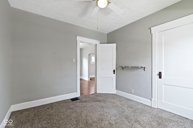 67 S 9th Ave, Beech Grove, IN 46107 - unfurnished bedroom featuring a textured ceiling, arched walkways, carpet, baseboards, and visible vents