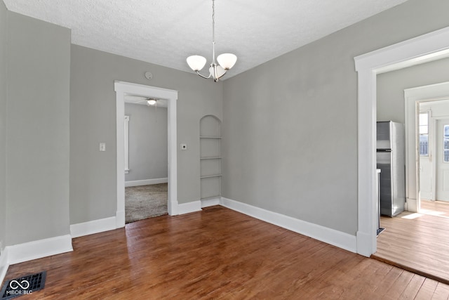 67 S 9th Ave, Beech Grove, IN 46107 - unfurnished dining area featuring a textured ceiling, baseboards, visible vents, built in features, and wood finished floors
