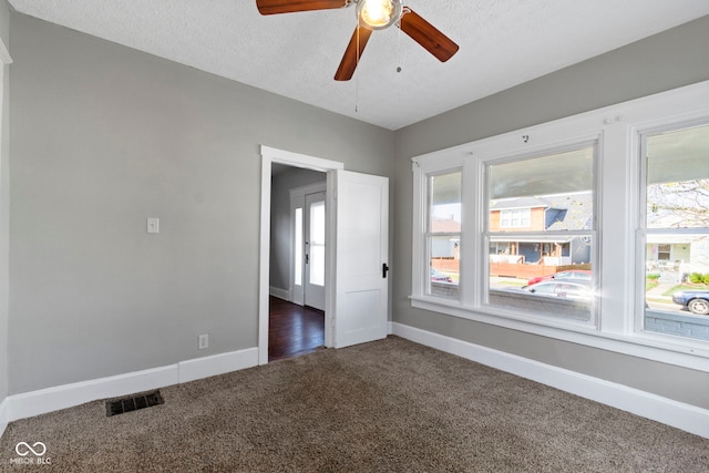 67 S 9th Ave, Beech Grove, IN 46107 - unfurnished room with dark colored carpet, a textured ceiling, baseboards, visible vents, and ceiling fan