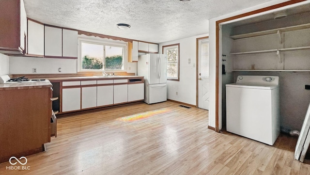 3346 S Lockburn St, Indianapolis, IN 46221 - kitchen with light wood finished floors, freestanding refrigerator, white cabinets, and washer / dryer