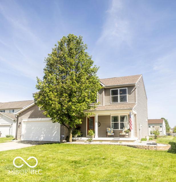 3896 Woods Bay Ln, Plainfield, IN 46168 - view of front of house featuring a porch, a garage, a front lawn, and driveway