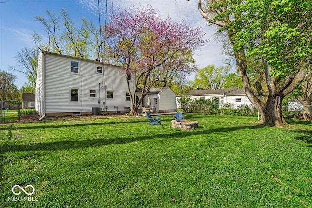 2204 Pamela Dr, Indianapolis, IN 46220 - rear view of property featuring a fire pit, a lawn, and fence