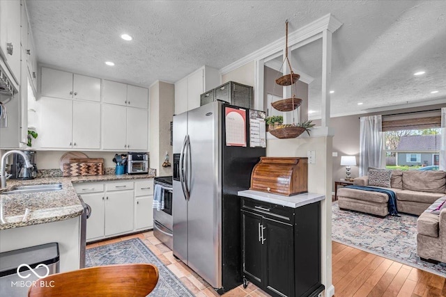 2204 Pamela Dr, Indianapolis, IN 46220 - kitchen featuring a textured ceiling, a sink, dark cabinetry, stainless steel appliances, and white cabinetry