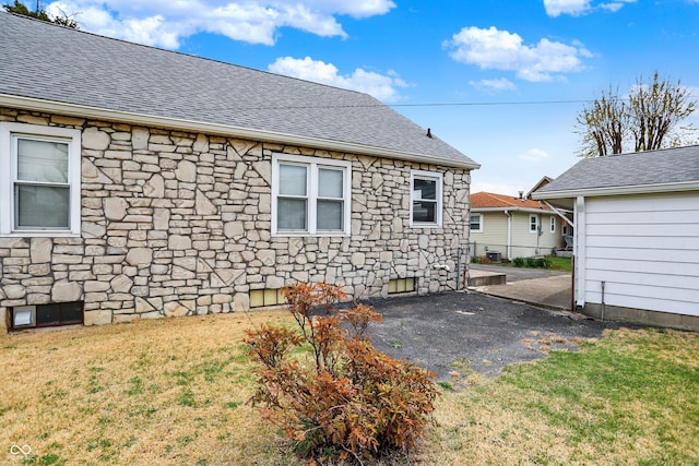 1194 S Faculty Dr, Indianapolis, IN 46241 - rear view of property with a yard, stone siding, a patio, and roof with shingles