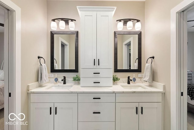 full bath featuring double vanity, a sink, and connected bathroom