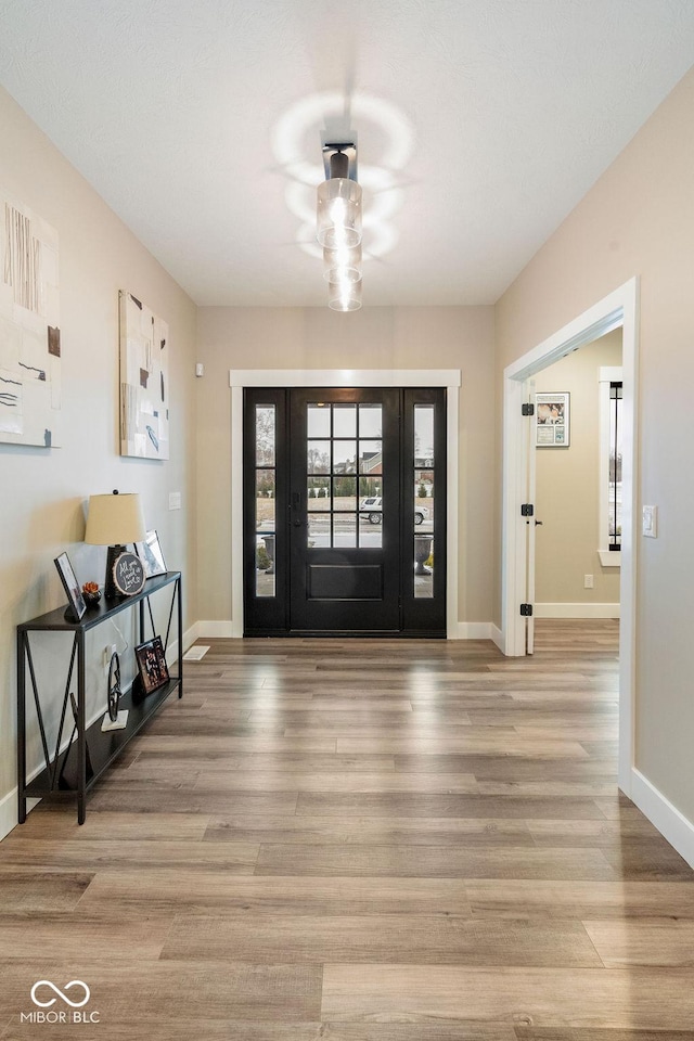 foyer entrance with light wood finished floors and baseboards