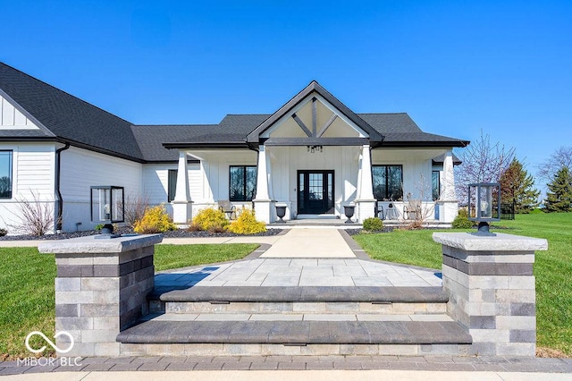 modern inspired farmhouse featuring a front yard, roof with shingles, board and batten siding, and covered porch
