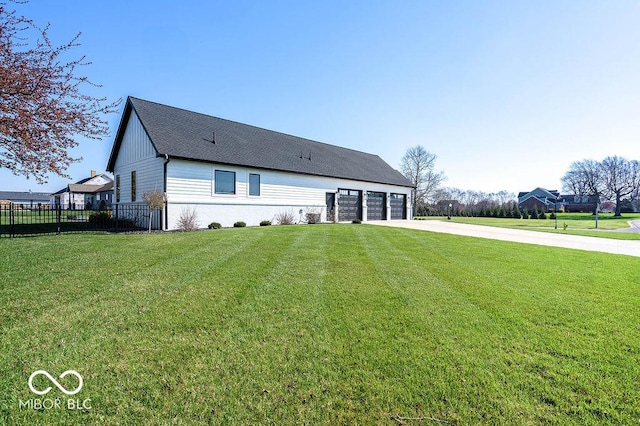 back of property with concrete driveway, fence, and a lawn