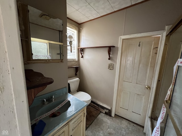 bathroom with toilet, vanity, and ornamental molding