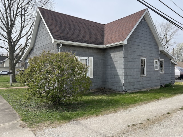 view of side of property with roof with shingles