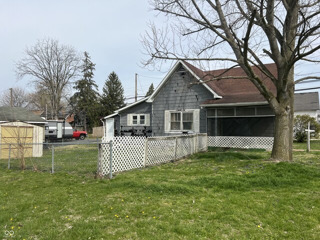 back of house with a yard, a sunroom, and fence