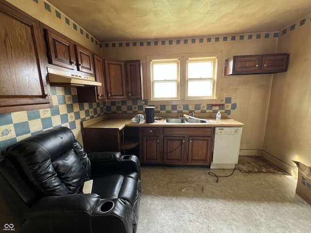 kitchen featuring dishwasher, under cabinet range hood, a sink, and light countertops