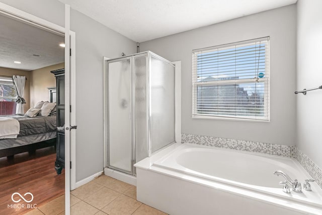 5817 Thompson Park Blvd, Indianapolis, IN 46237 - bathroom featuring a stall shower, tile patterned floors, a textured ceiling, connected bathroom, and a garden tub
