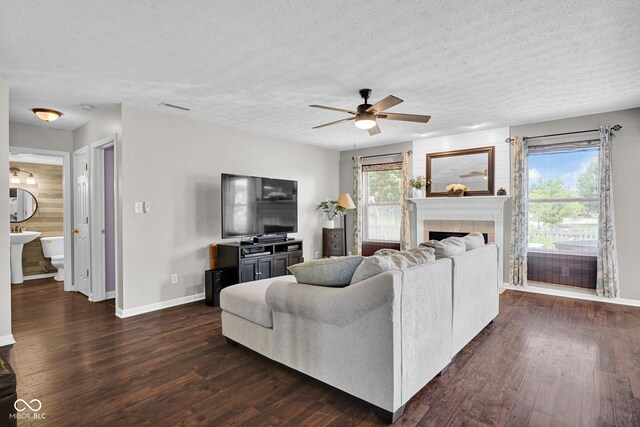 1280 Summer Ridge Ln, Brownsburg, IN 46112 - living room featuring a textured ceiling, a ceiling fan, dark wood finished floors, and a tile fireplace