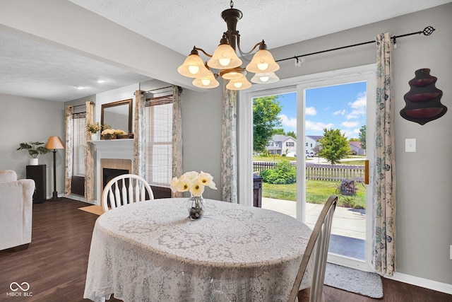 1280 Summer Ridge Ln, Brownsburg, IN 46112 - dining room with a chandelier, dark wood-style floors, a textured ceiling, and a tiled fireplace