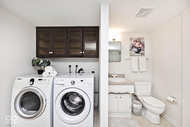 laundry area with a sink, light tile patterned flooring, visible vents, washer and dryer, and laundry area