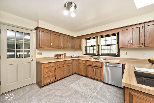 kitchen with light countertops, stainless steel dishwasher, brown cabinets, and a sink