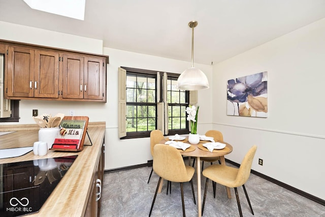 dining space with a skylight and baseboards