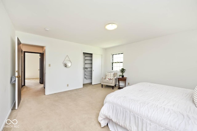bedroom with baseboards, light carpet, and a closet