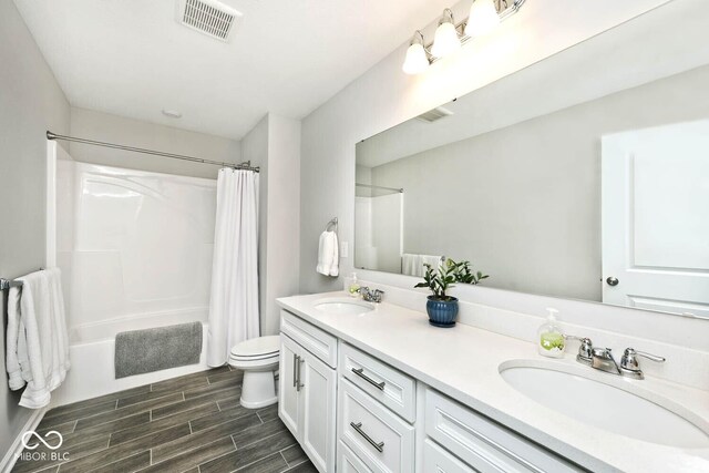 full bathroom with visible vents, toilet, shower / bath combo, and a sink