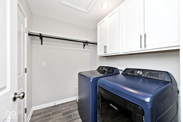 laundry room with washer and dryer, baseboards, cabinet space, and wood finish floors