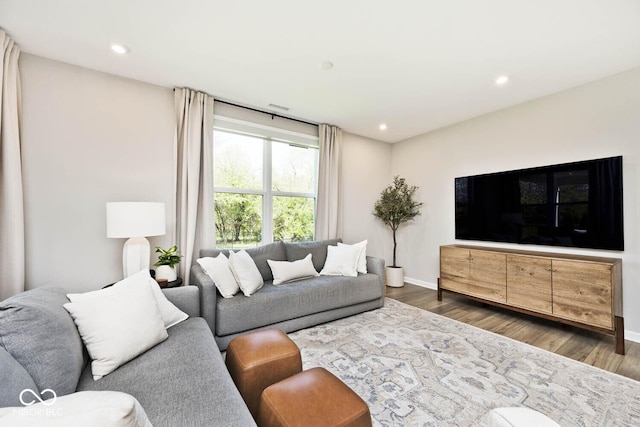 living area featuring recessed lighting, wood finished floors, and baseboards