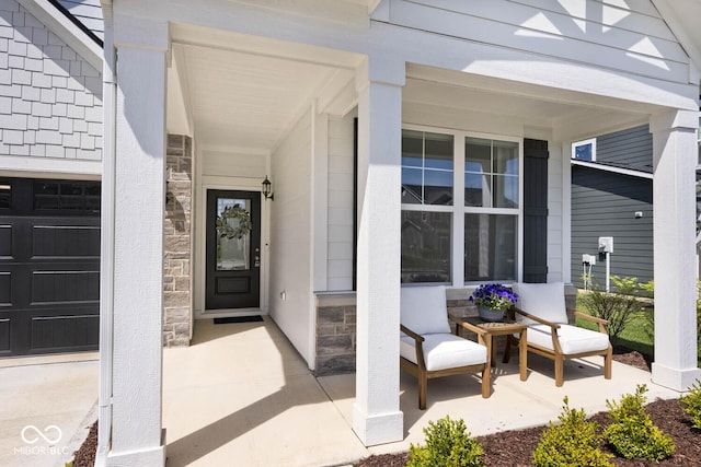 doorway to property featuring stone siding, covered porch, and a garage