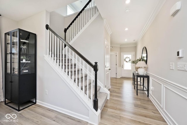 stairway featuring a wainscoted wall, wood finished floors, recessed lighting, and ornamental molding