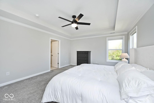 bedroom featuring a ceiling fan, crown molding, carpet floors, a tray ceiling, and baseboards