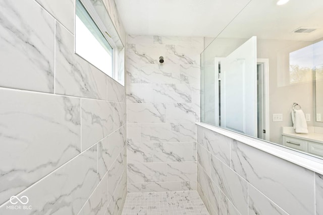 bathroom featuring visible vents, vanity, and a walk in shower