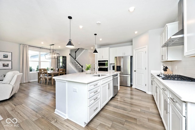 kitchen with light countertops, appliances with stainless steel finishes, decorative backsplash, and a sink