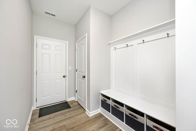 mudroom featuring light wood finished floors, baseboards, and visible vents