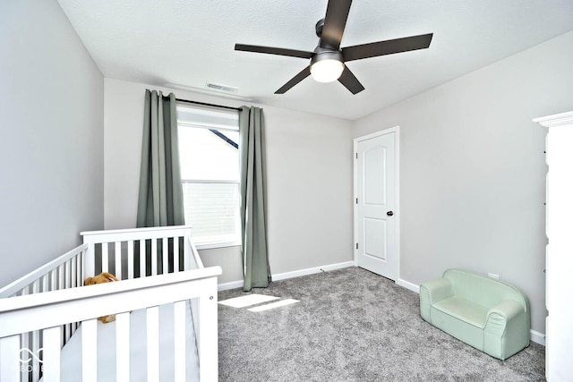 unfurnished bedroom featuring a nursery area, visible vents, carpet flooring, and baseboards