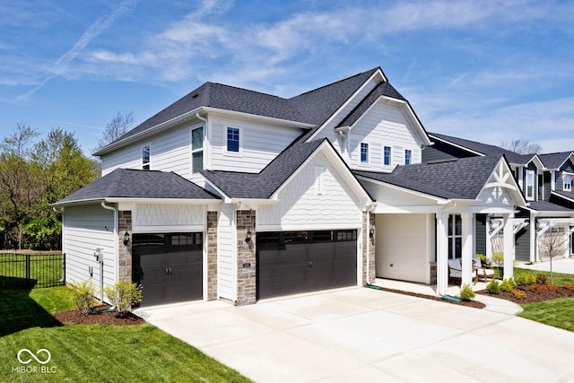 view of front of house with roof with shingles, a front lawn, driveway, fence, and a garage