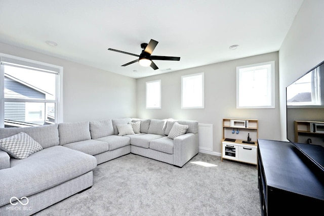 living area with visible vents, a ceiling fan, baseboards, and carpet