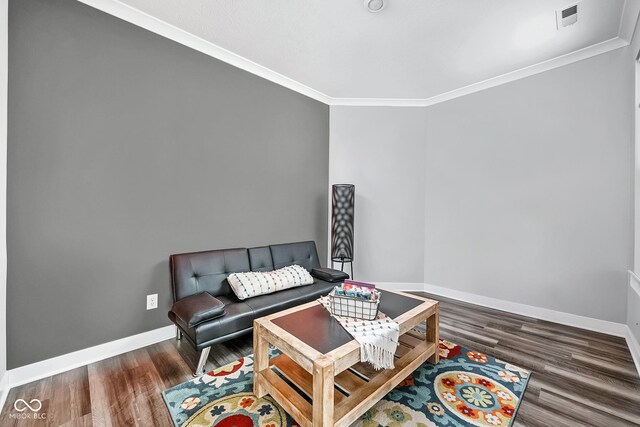 living area featuring ornamental molding, wood finished floors, and baseboards