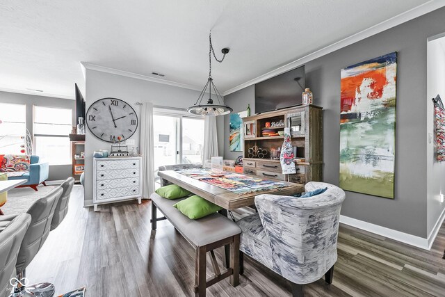 dining area featuring crown molding, wood finished floors, plenty of natural light, a chandelier, and baseboards