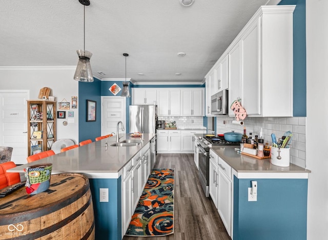 17302 Graley Pl, Westfield, IN 46074 - kitchen featuring appliances with stainless steel finishes, a sink, dark wood-style floors, decorative backsplash, and a kitchen bar
